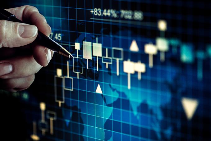 pen pointing at trading chart